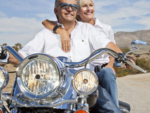 Senior couple on desert road sitting on motorcycle