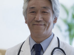 Portrait of mature doctor looking at camera and smiling