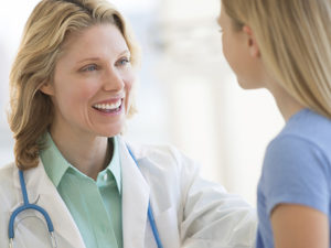 Female Doctor Looking At Girl In Clinic