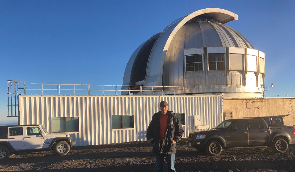 Man standing in front of metal observatory building