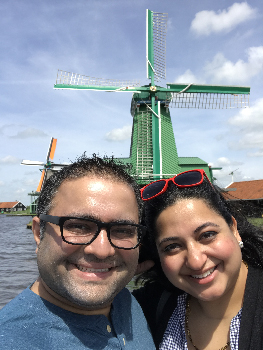 Two physicians smile in front of windmill