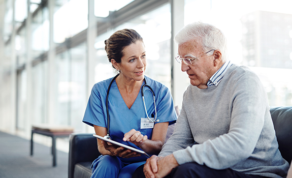 Female physician speaking with elderly senior patient