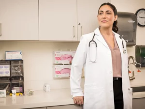 Female physician leans against counter in treatment room
