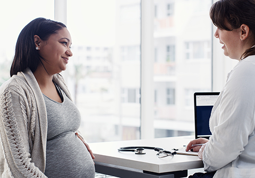 physician speaking with pregnant patient