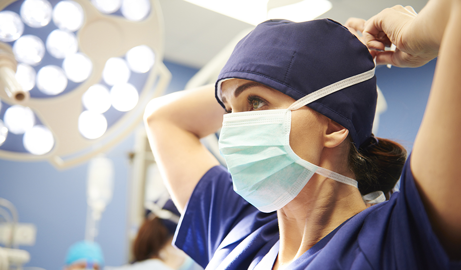 Female CRNA puts on a surgical mask in the OR