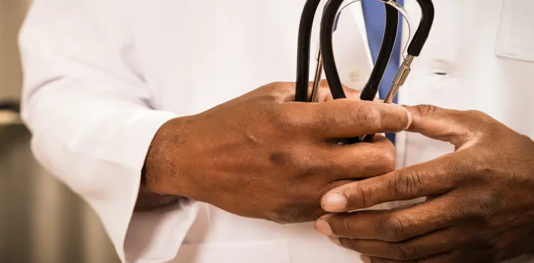 A locums physician holds a stethoscope