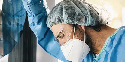 Image of healthcare provider wearing a surgical mask and hairnet.